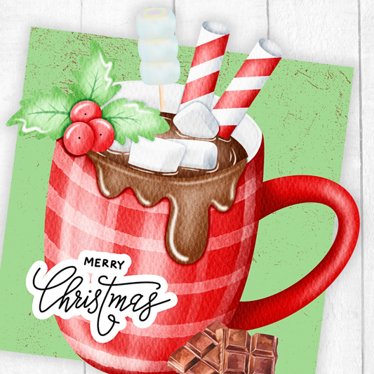 Red plaid mug with hot chocolate, marshmallows, and Christmas decorations on a green background.