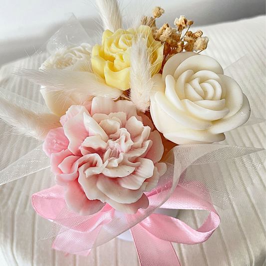 Decorative flower arrangement with pink, yellow, and white flowers on a light background. PASTEL CANDLES FLOWER BOUQUET
