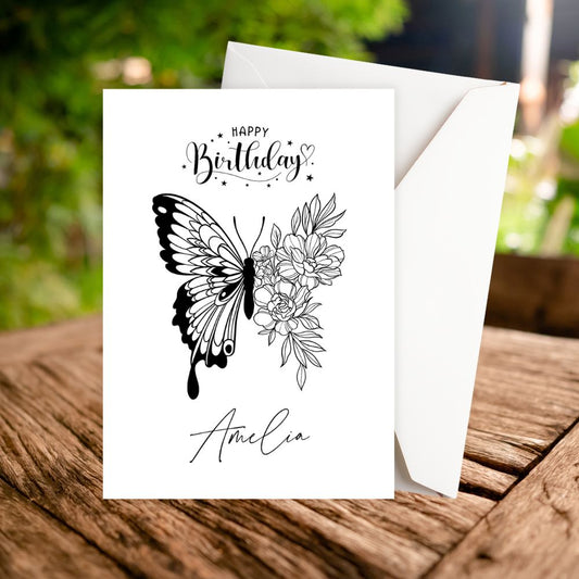 Birthday card with butterfly and floral design on a wooden surface