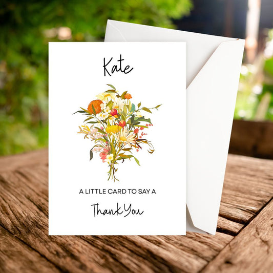 Greeting card with floral design and text on a wooden surface. Autumn Flowers Thank You Personalised Card