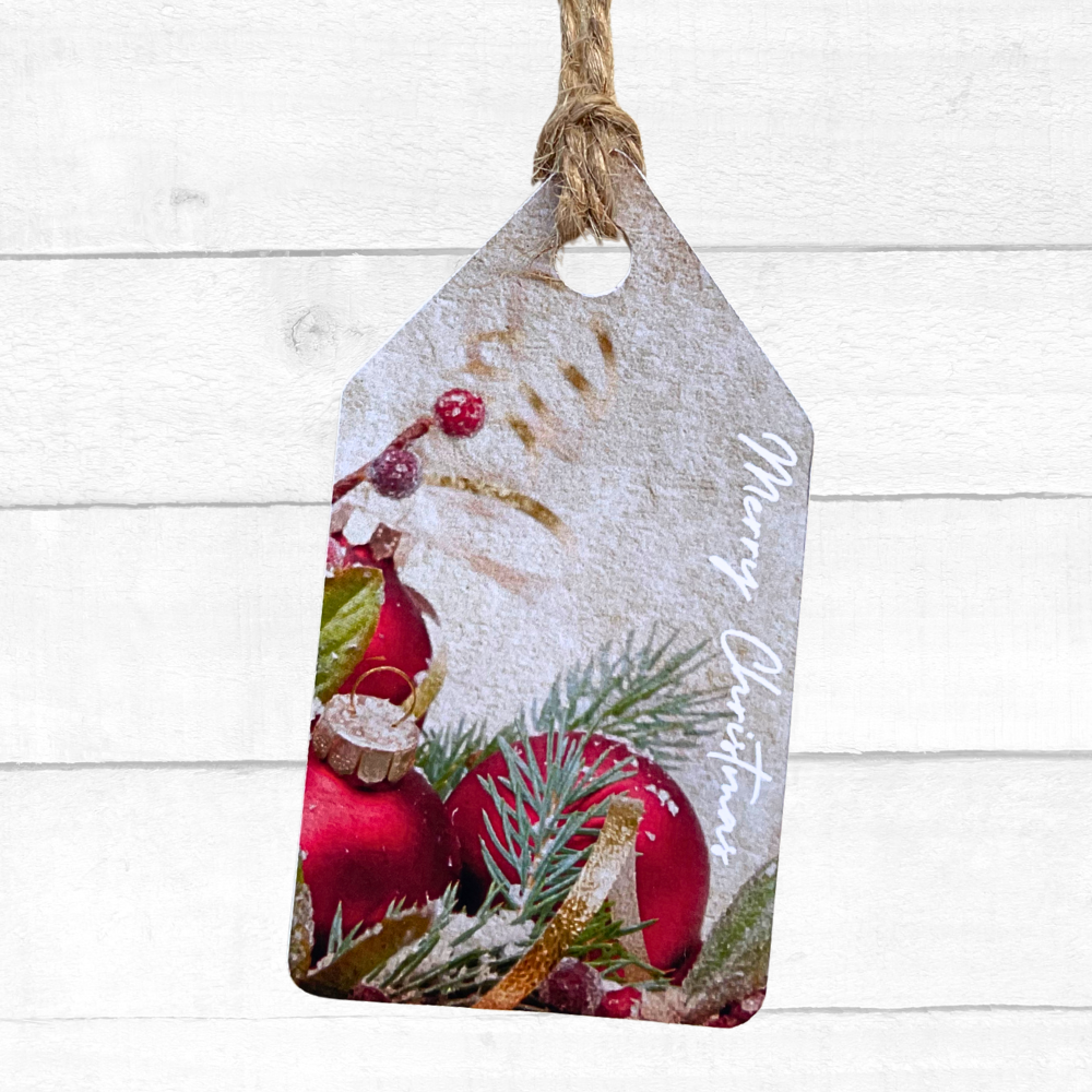Decorative Christmas tag with red ornaments and greenery on a white wooden background. Bauble Christmas Gift Tag Set