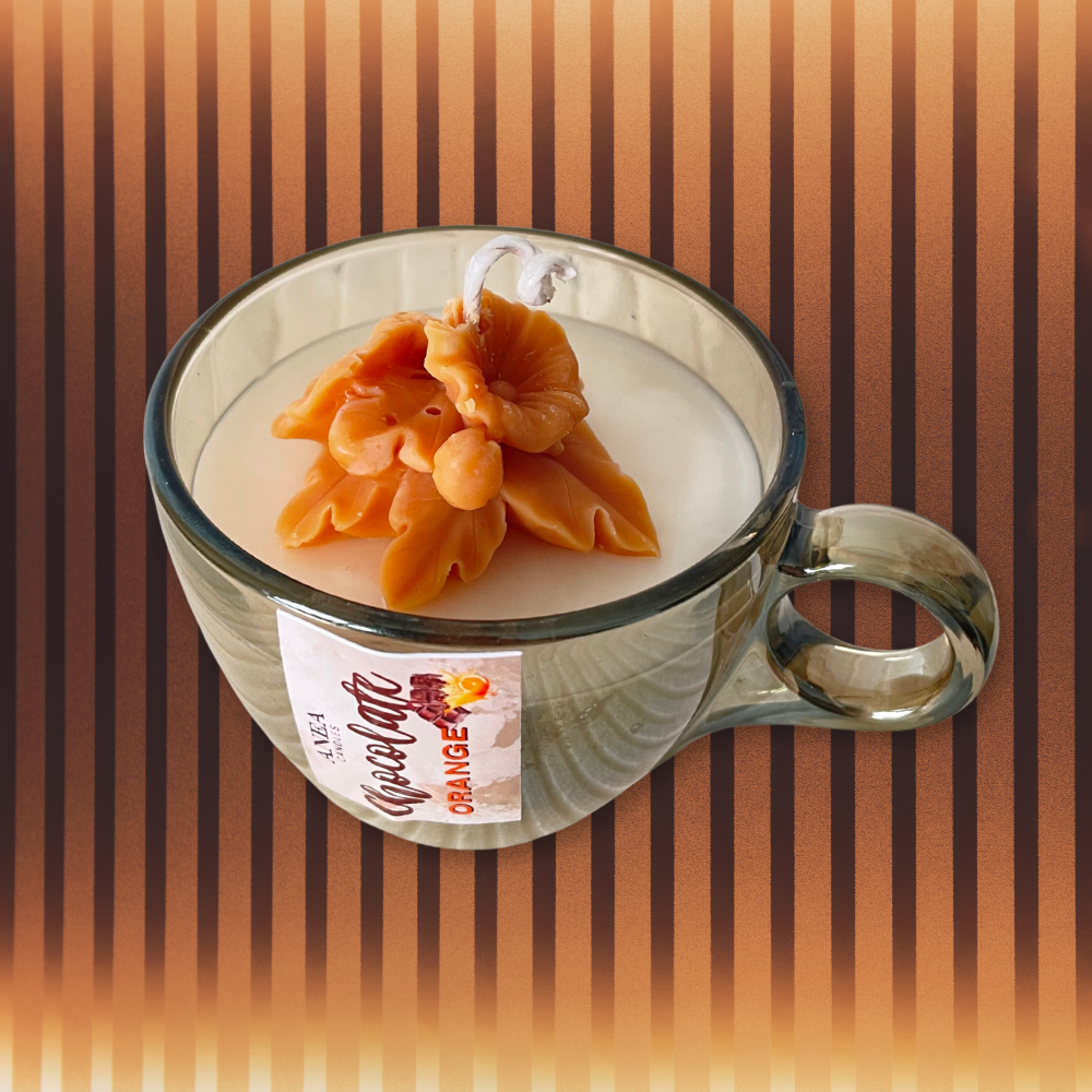 Cup of coffee with a decorative orange flower on a striped background. CHOCOLATE ORANGE PLANT CANDLE