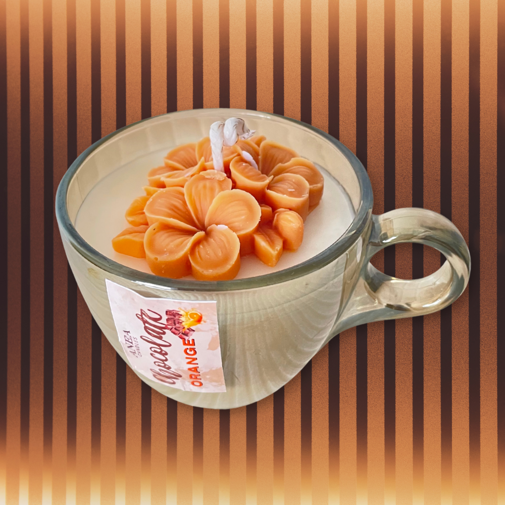 Candle in a glass mug with an orange flower design on a striped background. CHOCOLATE ORANGE FLOWERS CANDLE
