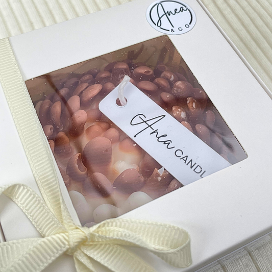 Candle in a box with a visible brand label on a white background. CHRYSANTHEMUM CINNAMON BUN CANDLE GIFT BOX