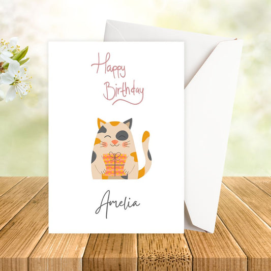 Birthday card with a cat illustration and 'Happy Birthday' text on a wooden surface. Cream Cat Birthday Personalised Card