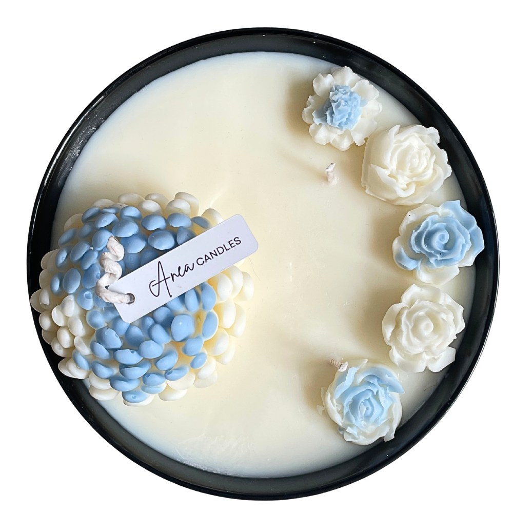 Decorative candle with blue and white floral designs and 'Aera Candles' label.FLOWER NATURAL SOY CANDLE