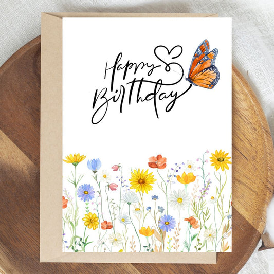 Birthday card with flowers and a butterfly on a wooden surface. Flower Field Happy Birthday Card