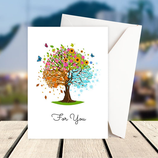 Greeting card with a colorful tree design on a wooden surface with a blurred background