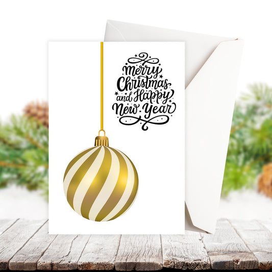 Greeting card with gold and white striped Christmas ball and festive text on a wooden surface with blurred greenery.GOLDEN BAUBLE CHRISTMAS CARD