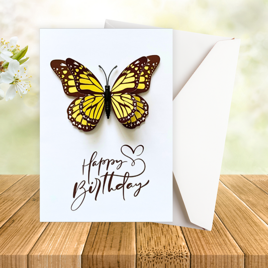 Greeting card with a butterfly and 'Happy Birthday' text on a wooden surface.