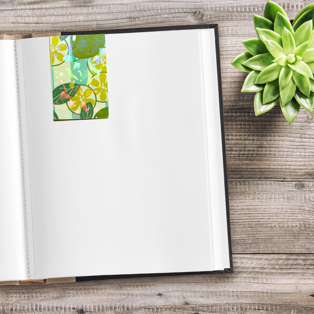Open notebook with a floral bookmark on a wooden surface next to a green succulent plant. Juicy Fruit Bookmark Set