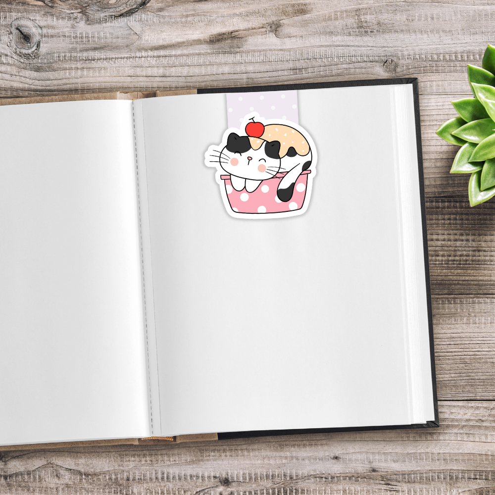 Open notebook with a cute illustration of a cat in a polka dot dress on a wooden surface. Kawaii Cats Magnetic Bookmark
