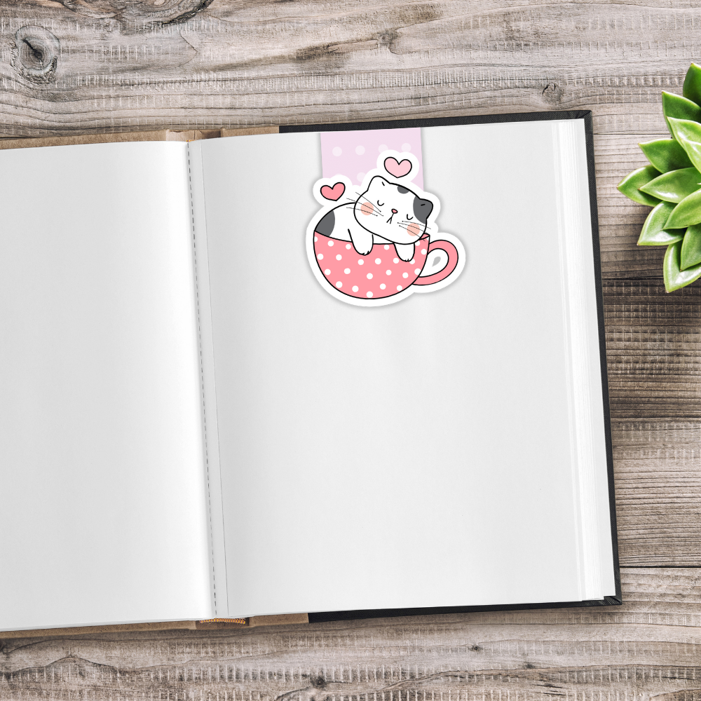 Open notebook with a cute cat sticker on a wooden surface. Kawaii Cats Magnetic Bookmark