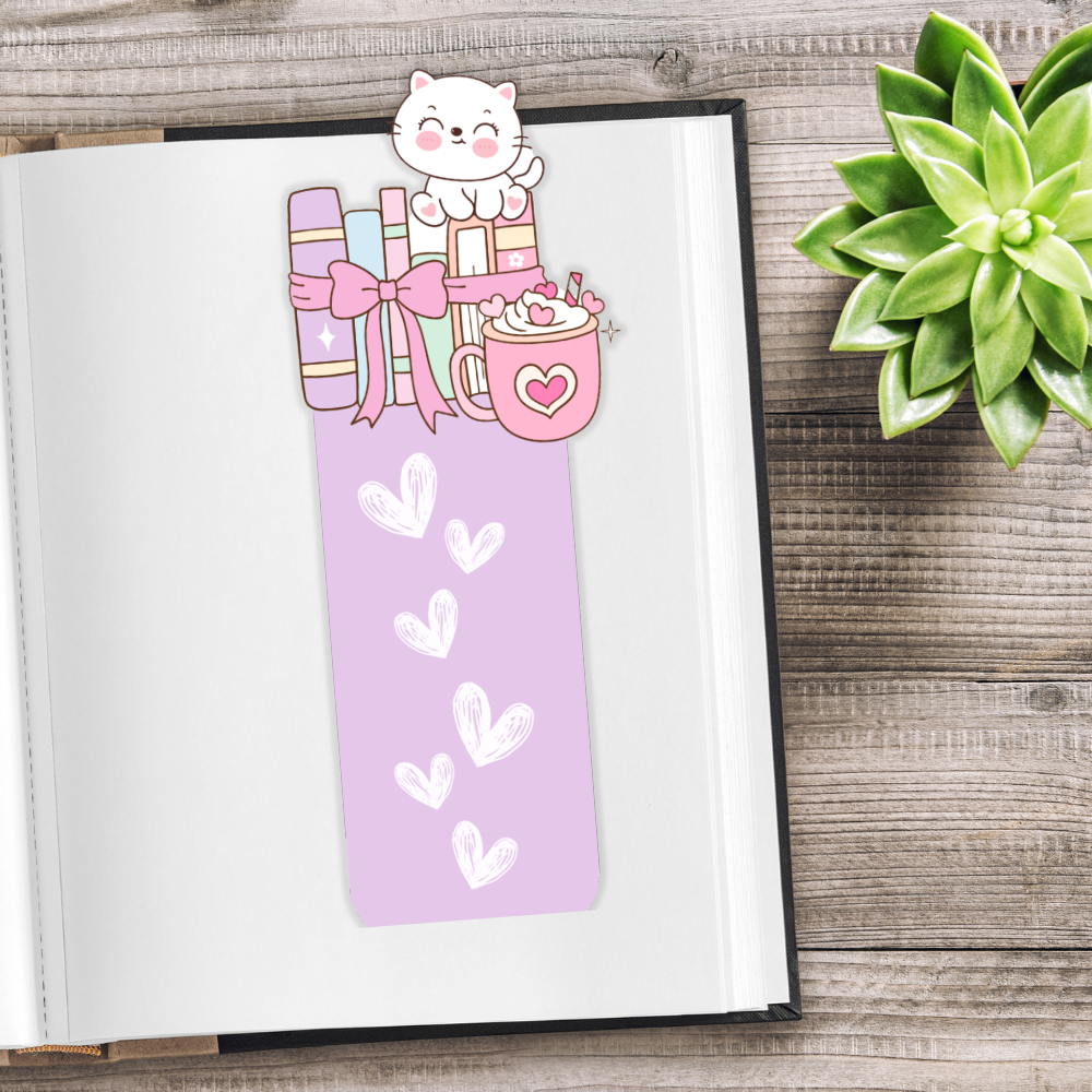 Bookmark with a cat and gift design on an open book next to a succulent plant.Kawaii Kitten Bookmark