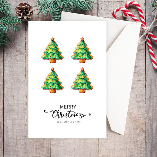 Four Christmas tree cookies on a card with 'Merry Christmas and Happy New Year' text, surrounded by festive decorations on a wooden surface. LITTLE TREES CHRISTMAS CARD