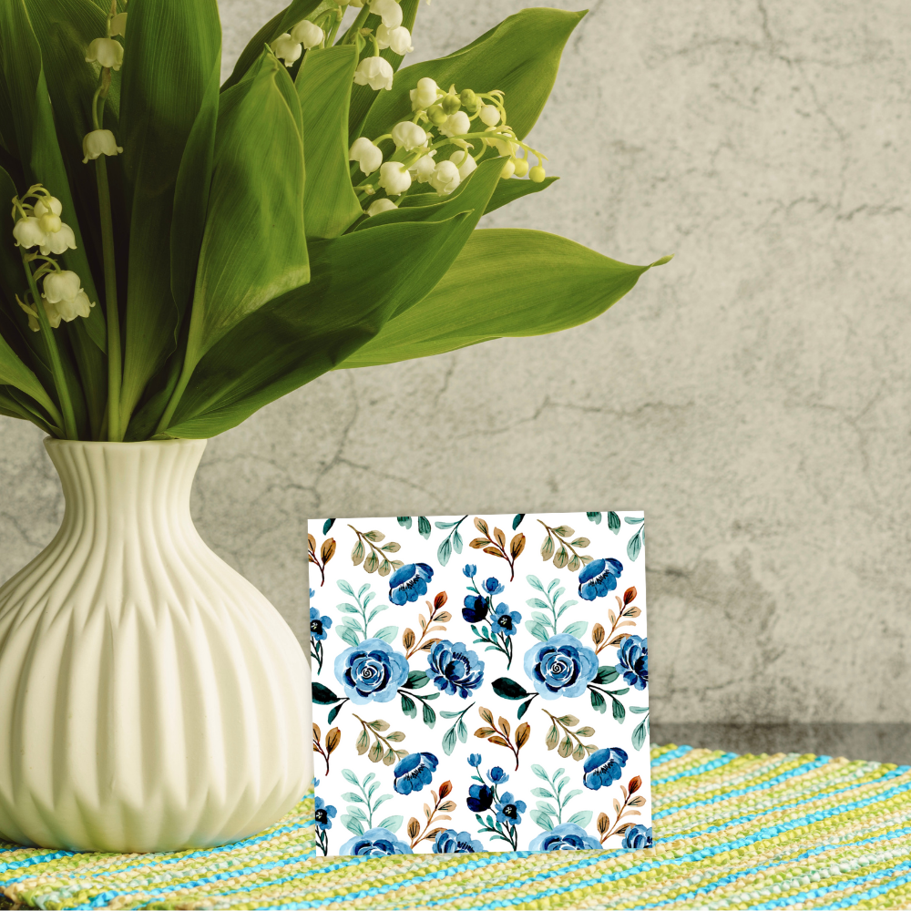 Vase with green leaves and white flowers next to a floral patterned notebook on a textured surface. Navy Flowers Happy Birthday Card