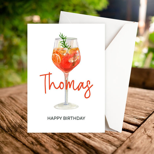 Personalised Birthday card with a cocktail illustration and 'Happy Birthday' text on a wooden surface.