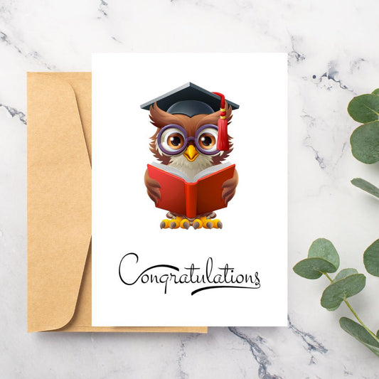 Graduation-themed greeting card with an owl wearing a cap and holding a book, on a marble surface with a plant. Owl Reading Congratulations Graduation Card