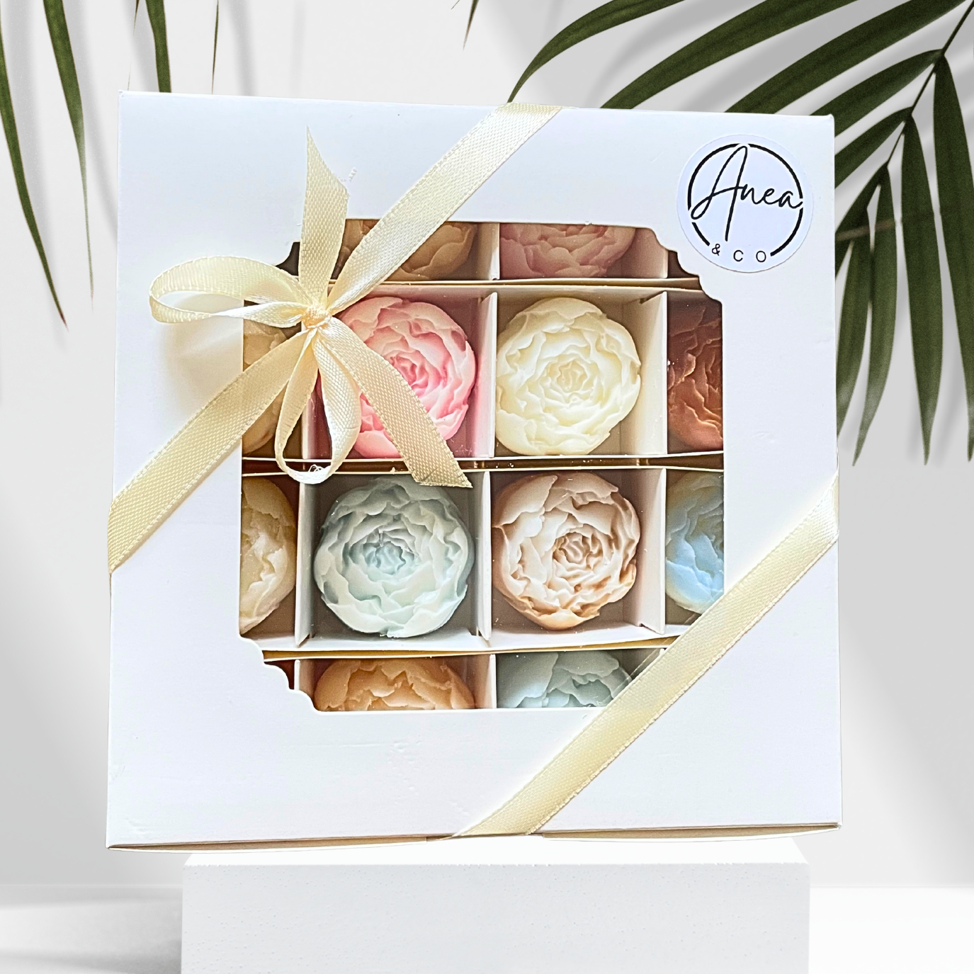Box of pastel-colored soap bars with a decorative ribbon, featuring the brand 'Anea & Co'. PEONIES WAX MELTS GIFT BOX