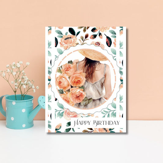 Birthday card with floral design and photo of a woman, placed on a surface with a pink background. Peach Flowers Happy Birthday Card
