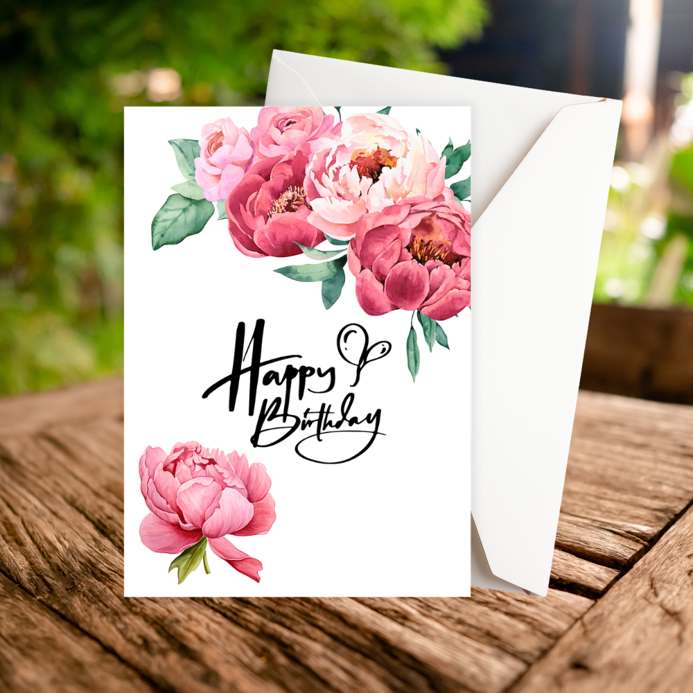 Birthday card with pink flowers and 'Happy Birthday' text on a wooden surface