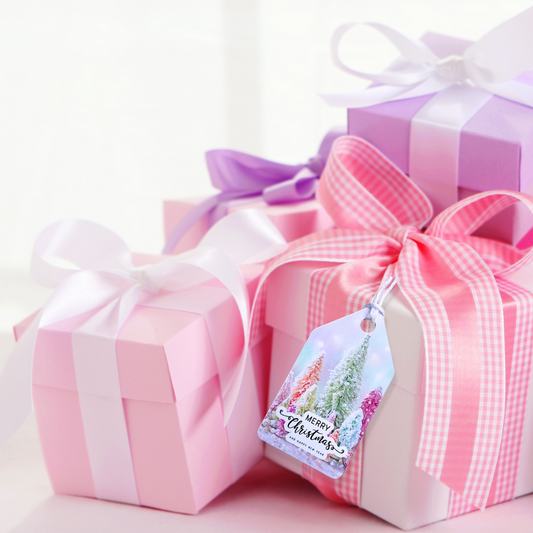 Three gift boxes with ribbons and a Christmas tag on a light pink background. Pink Christmas Gift Tag Set