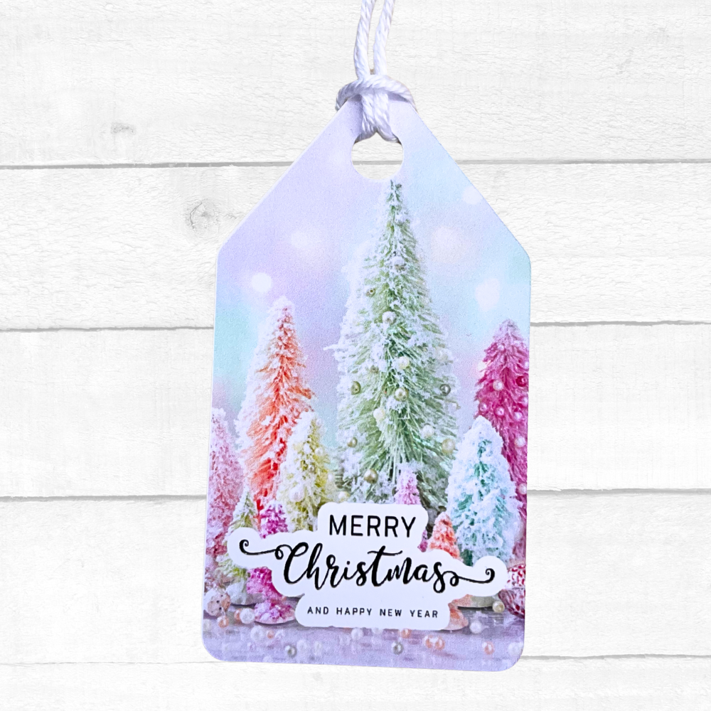 Decorative Christmas tag with snowy trees and 'Merry Christmas and Happy New Year' text on a white wooden background. Pink Christmas Gift Tag Set