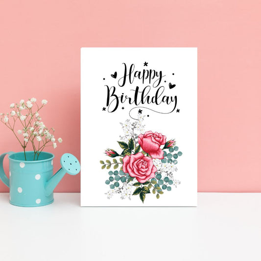Happy Birthday card with pink roses and greenery next to a turquoise watering can on a pink background. Pink Roses Happy Birthday Card