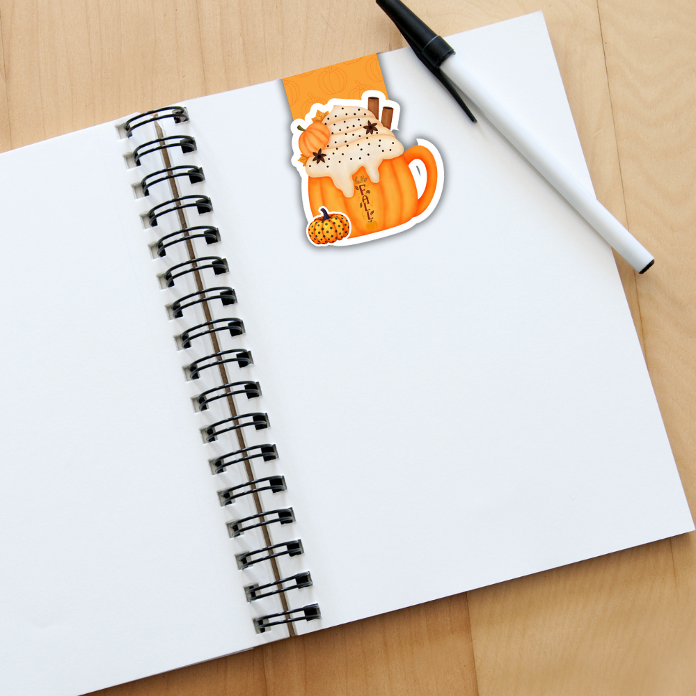 Notebook with a sticker of a fox in a pumpkin patch on a wooden surface. Pumpkin Spice Magnetic Bookmark