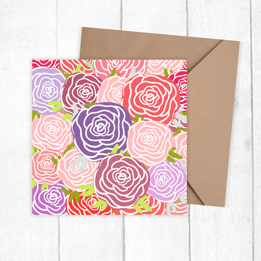 Floral patterned card with a brown envelope on a white wooden surface. Roses Bouquet Birthday Card