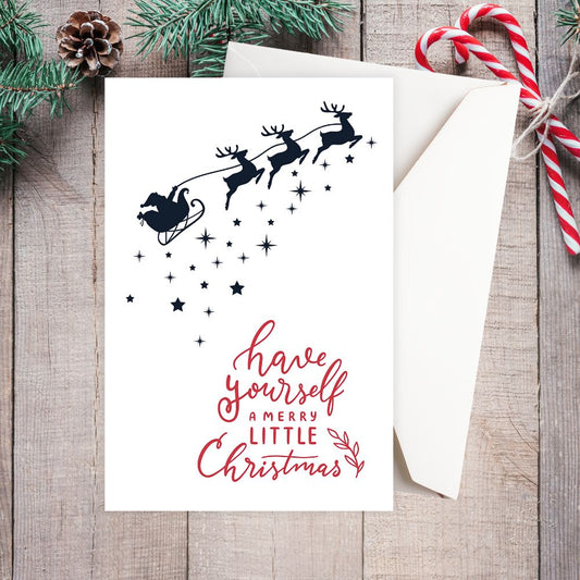 Christmas card with reindeer and text on a wooden surface with candy canes and pine cones. STARRY NIGHT CHRISTMAS CARD