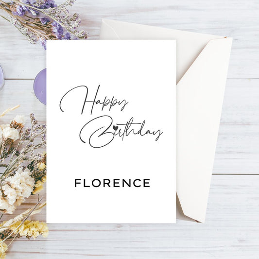 Happy Birthday Florence card on a wooden surface with dried flowers.