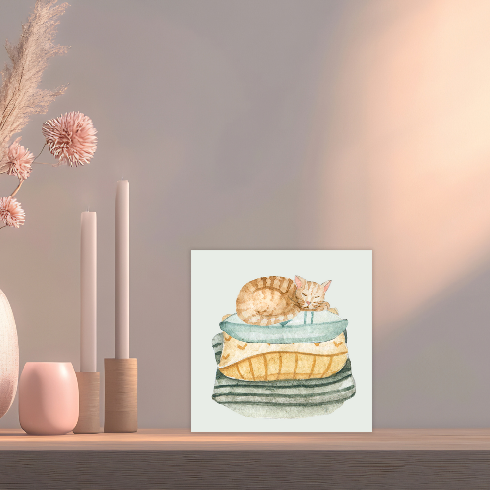 Framed artwork of a cat on a cushion on a wooden shelf with decorative items greeting card