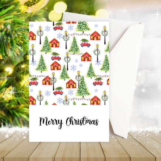 Christmas-themed card with festive design on a wooden surface with Christmas decorations.VILLAGE MERRY CHRISTMAS CARD