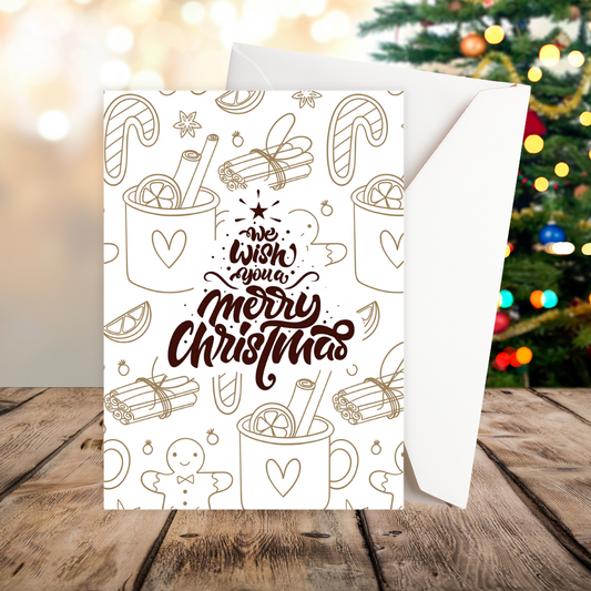 Christmas card with festive illustrations and 'Merry Christmas' text on a wooden surface with a blurred Christmas tree in the background. We Wish you A Merry Christmas Card