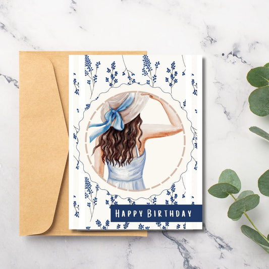 Birthday card with a woman in a blue dress and hat, surrounded by flowers, on a marble surface with a plant. Wild Flowers Happy Birthday Card