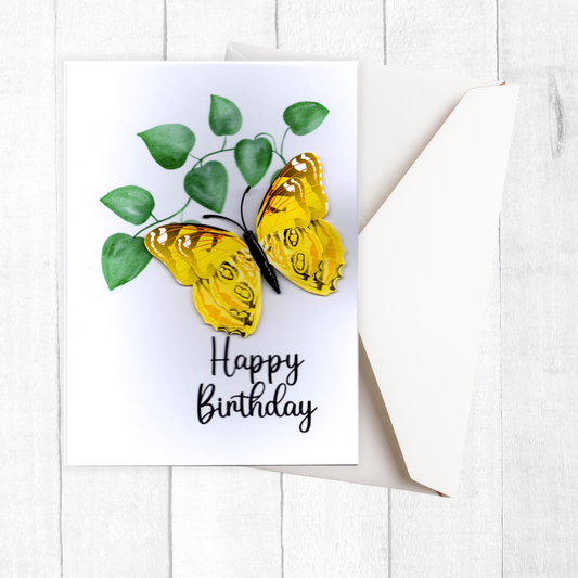 Birthday card with yellow butterfly and green leaves on a white background
