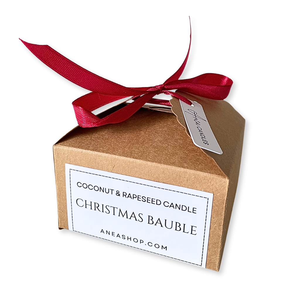 Coconut and rapeseed candle Christmas bauble in a brown box with a red ribbon on a white background. BAUBLE CHRISTMAS CANDLE