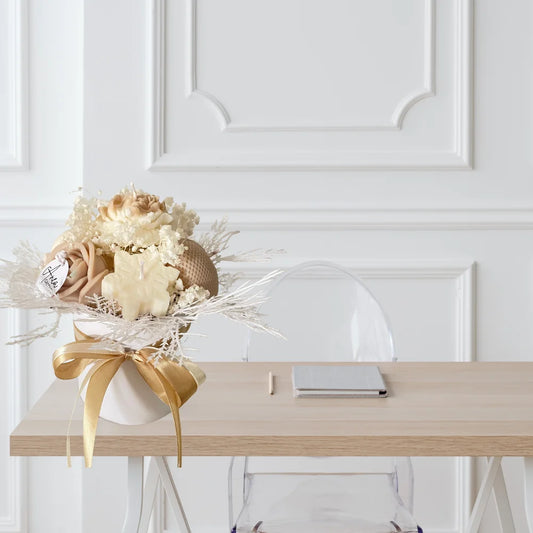 Bouquet of flowers with a gold ribbon on a wooden table against a white paneled wall. christmas candle ornaments