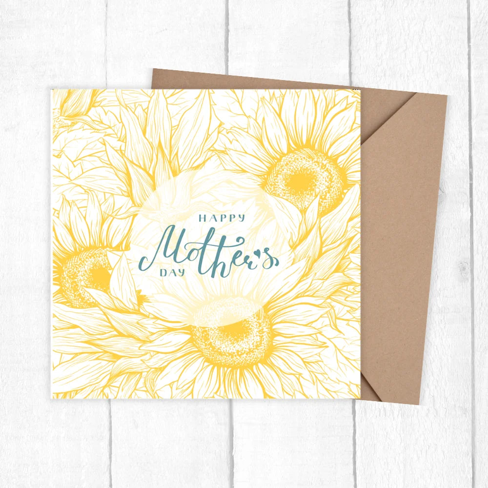 Greeting card with sunflower design and 'Happy Mother's Day' text on a white wooden surface. SUNFLOWER MOTHER'S DAY CARD