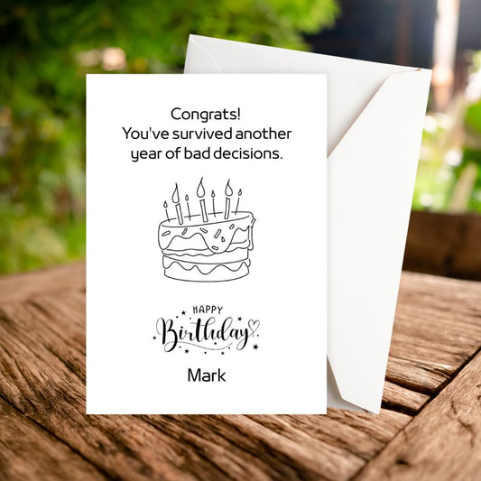 Birthday card with humorous message and cake illustration on a wooden surface. witty personalised birthday card