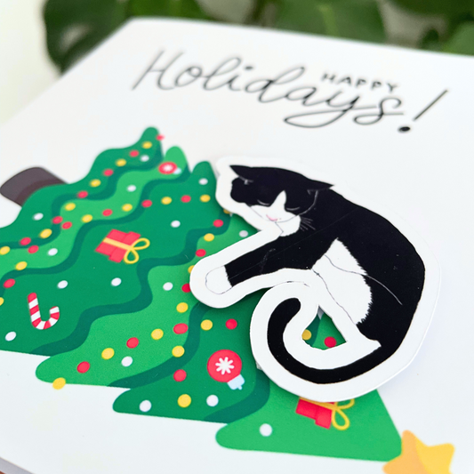 Holiday card with a black and white cat climbing a decorated Christmas tree, featuring the text 'Happy Holidays!'.3D Cat on the Tree Christmas Card