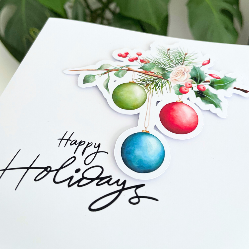 Decorative card with Christmas ornaments and 'Happy Holidays' text on a white background. 3D Holidays Bauble Christmas Card