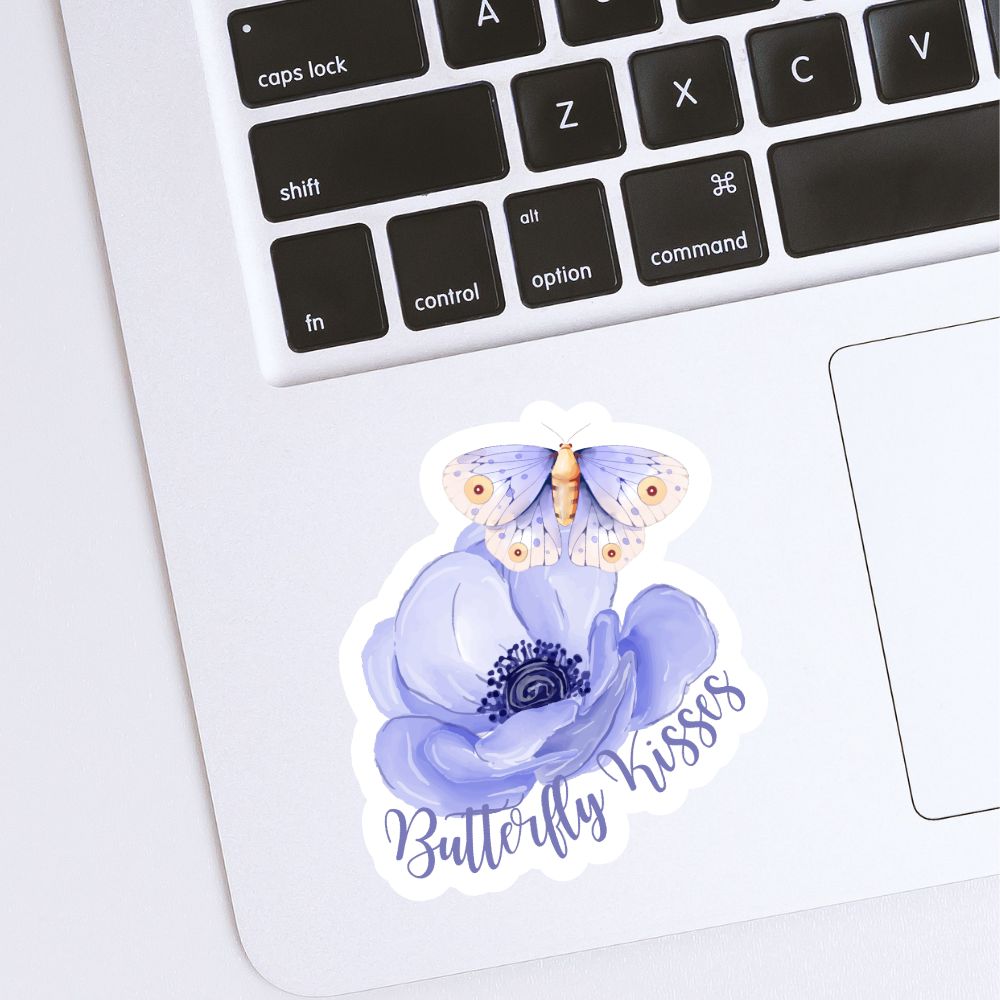 Sticker of a butterfly on a flower with 'Butterfly Kisses' text on a laptop keyboard. BUTTERFLY KISSES STICKER