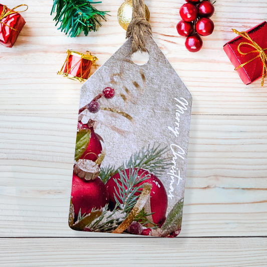 Decorative Christmas tag with red ornaments and pine branches on a wooden surface.Bauble Christmas Gift Tag Set