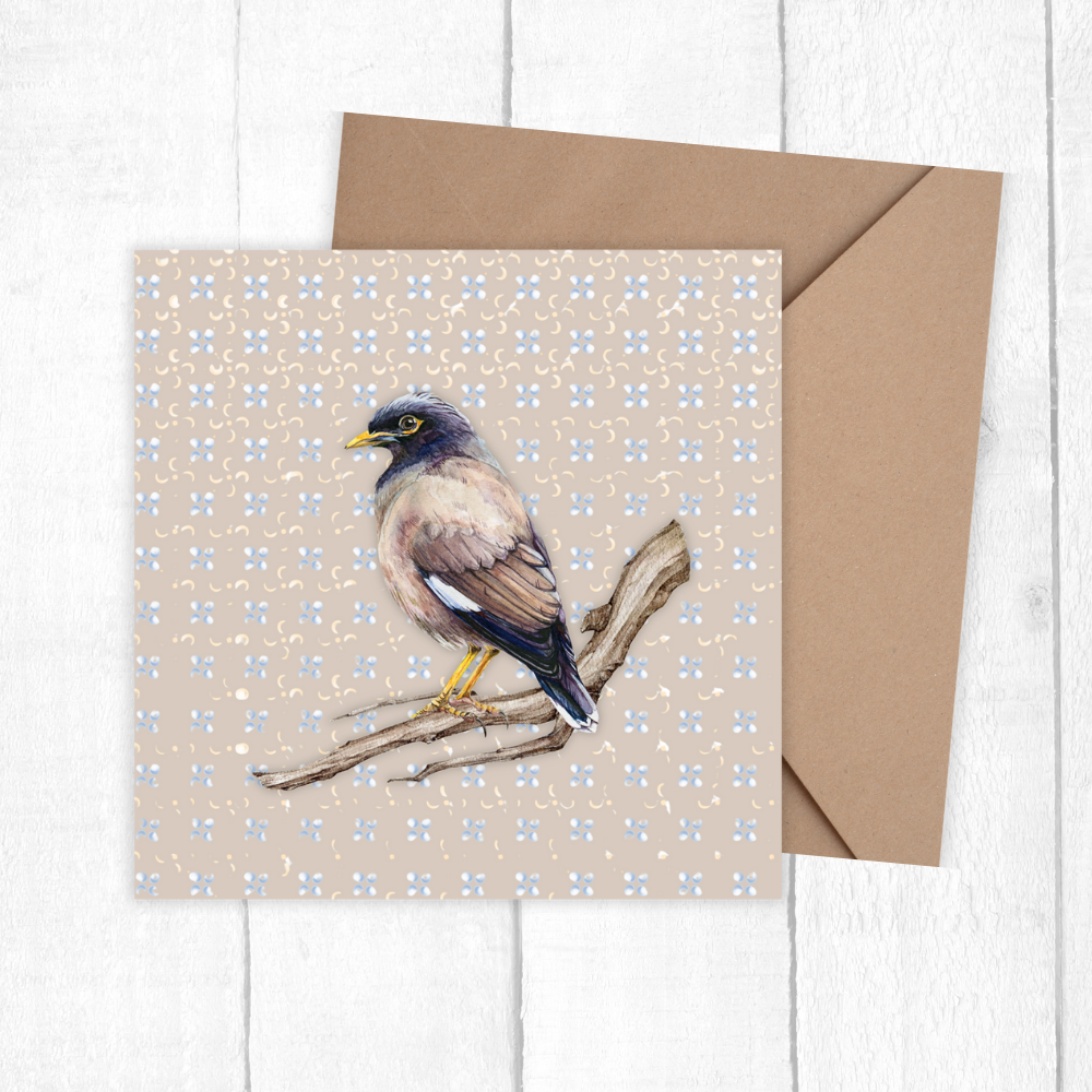 Greeting card with a bird illustration on a floral patterned background, accompanied by a brown envelope.