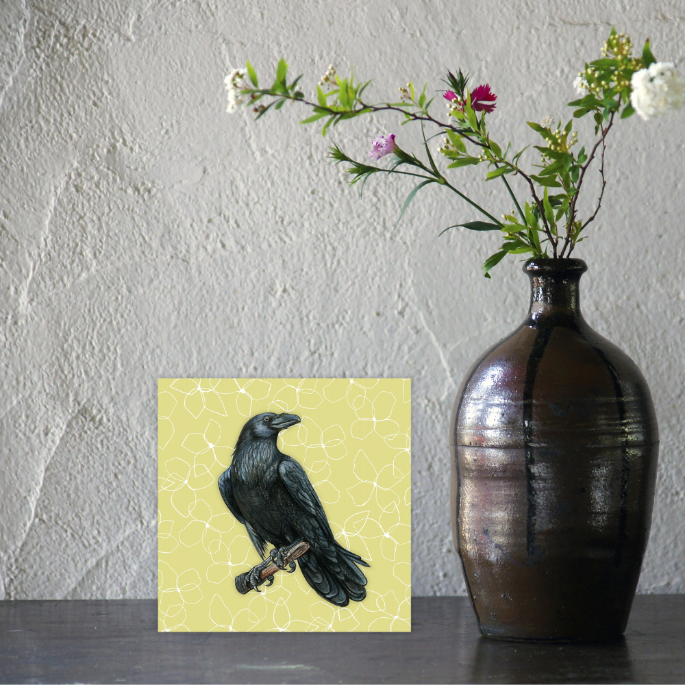 Vase with flowers next to a painting of a raven on a textured wall background birthday card