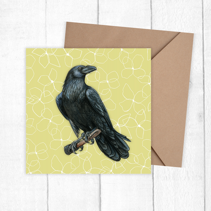 Greeting card with a black crow illustration on a yellow background, accompanied by a brown envelope.