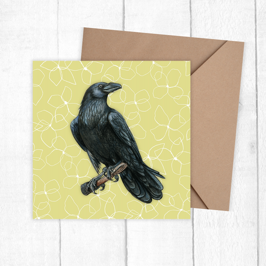 Greeting card with a black crow illustration on a yellow background, accompanied by a brown envelope.