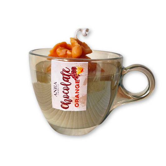Clear mug with chocolate orange flavor label and candy on a white background. CHOCOLATE ORANGE PLANT CANDLE